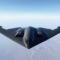 B-2 Spirit Stealth Bomber Flying Over Snowy Terrain, Aerial Photograph. Modern Military Aviation and Technology Concept. Blue Sky background