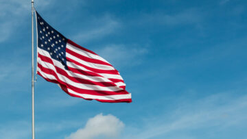 American Flag against the backdrop of a blue sky and clouds.