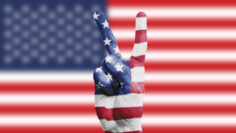 USA national flag painted onto a male hand showing a victory, peace, strength sign
