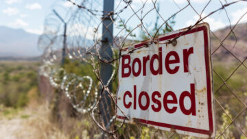 Grungy border closed warning sign on fence with barbed wire with copy space for text. Concept of illegal immigration control and security