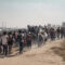 Illustration of mass immigration of people, the concept of social problems. Large group of refugees walking on a dusty road, representing the mass movement and challenges they face.