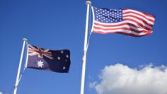 Flag of United States of America fly beside the flag of Australia against clear blue sky