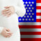 Beautiful pregnant woman belly against American flag background. Demographics and pregnancy in USA concept
