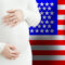 Beautiful pregnant woman belly against American flag background. Demographics and pregnancy in USA concept
