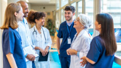 Medical team talking and smiling in hospital corridor