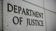 Department of Justice” engraved in grey, stone-like wall, close up