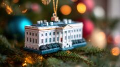White House ornament hanging on a Christmas tree with colorful lights