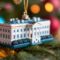 White House ornament hanging on a Christmas tree with colorful lights