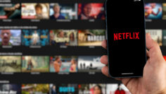 Male hand holding a smartphone with Netflix App on the screen wi