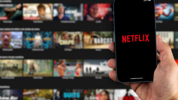 Male hand holding a smartphone with Netflix App on the screen wi