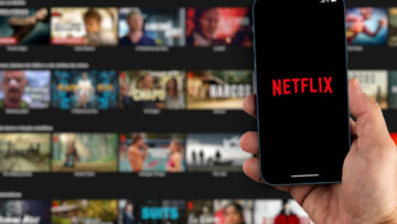 Male hand holding a smartphone with Netflix App on the screen wi