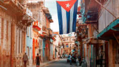 Cuban flags, people and aged buildings in Old Havana