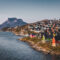 Nuuk capital of Greenland with Beautiful small colorful houses in myggedalen during Sunset Sunrise Midnight Sun. Sermitsiaq Mountain in Background. Blue and pink Sky.