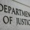 Department of Justice” engraved in grey, stone-like wall, close up