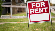For rent sign in the yard in front of a house