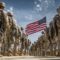 United states army soldiers in camouflage standing and marching in formation with the american flag waving under a blue sky, symbolizing service, duty, patriotism, and unity