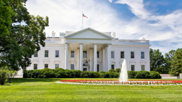 The White House on a summer day with the American flying over it.