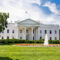 The White House on a summer day with the American flying over it.
