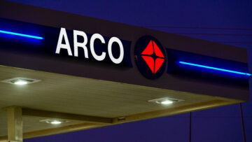 An ARCO gas station canopy with illuminated brand signage at night, illustrating retail fueling operations, petroleum distribution, and consumer transportation services