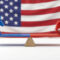 US political balance concept: Democrat donkey and Republican elephant on seesaw against American flag.