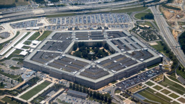 Aerial view of the Pentagon complex with surrounding roads, parking and greenery. g