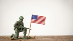 Memorial Day with a green toy soldier and American flag on a white background, national day concept with copy space for text