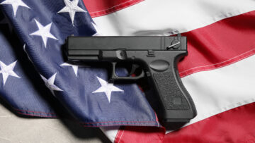 Gun control and second amendment debate, black handgun resting on a folded United States flag national security and constitutional rights