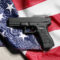 Gun control and second amendment debate, black handgun resting on a folded United States flag national security and constitutional rights